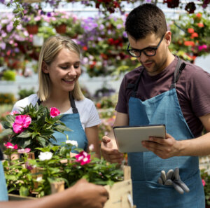 Cheerful young gardeners working in a greenhouse